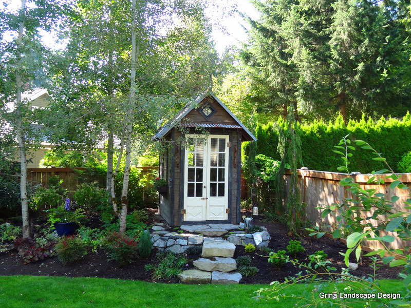 A garden shed is a special destination thanks to the hardscape steps to the doorway and well thought out shrubs, trees and perennials.